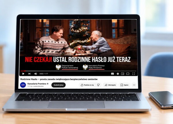 Laptop na jasnym biurku z otwartym filmem napisem Rodzinne Hasło. Obok leży smartfon.