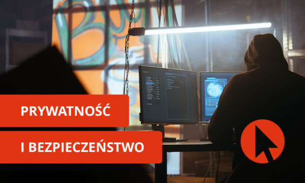 Zakapturzony mężczyzna patrzy w komputer w ciemnym pomieszczeniu