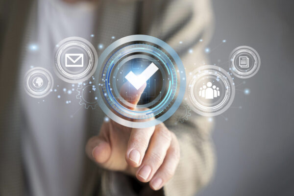 Osoba dotyka cyfrowej ikony potwierdzenia na ekranie, symbolizującej weryfikację danych firmy w internecie. Grafika przedstawia proces, jak sprawdzić firmę i potwierdzić jej wiarygodność online.